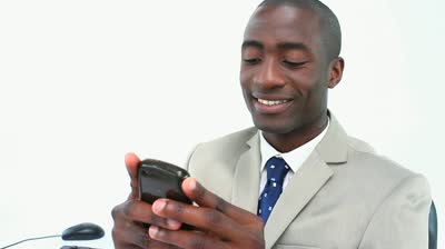 stock-footage-black-businessman-texting-on-a-smartphone-in-his-office