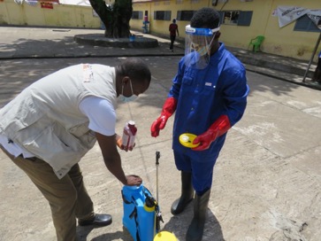 ’agent de Tdh en train de doser le liquide insecticide dans le pulvérisateur.
