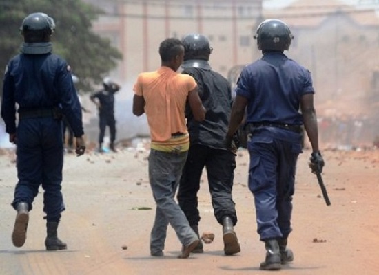 Des agents de la police arrêtent un manifestant à Conakry