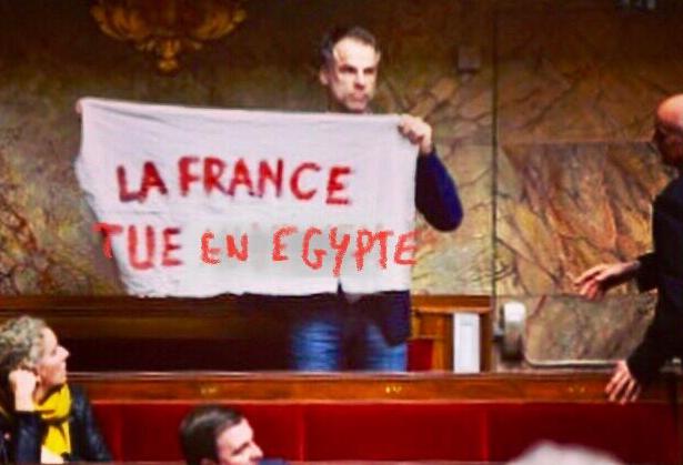 Le député français Sébastien NADOT  brandissant une banderole à l'Assemblée nationale française