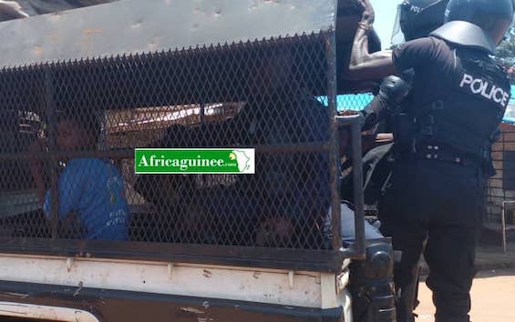 Un policier agrippé à l'arrière d'un pick up de la police à Cosa