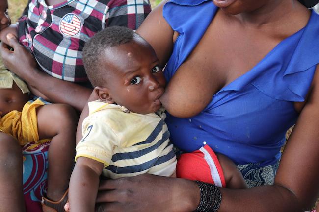 Une femme du groupement féminin de Sabougnouma nourrit son bébé. Région de Kankan, Guinée.